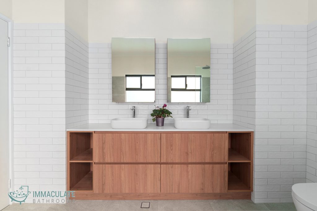 Modern bathroom renovation with double vanity, timber cabinetry, subway tiles, and dual mirrors – Immaculate Bathrooms Perth.