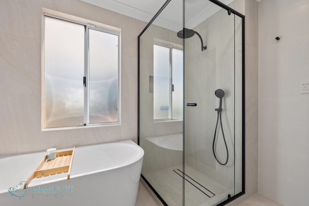 Modern Perth bathroom renovation with freestanding bath, black-framed shower screen and matte-black shower fixtures – Immaculate Bathrooms Perth.