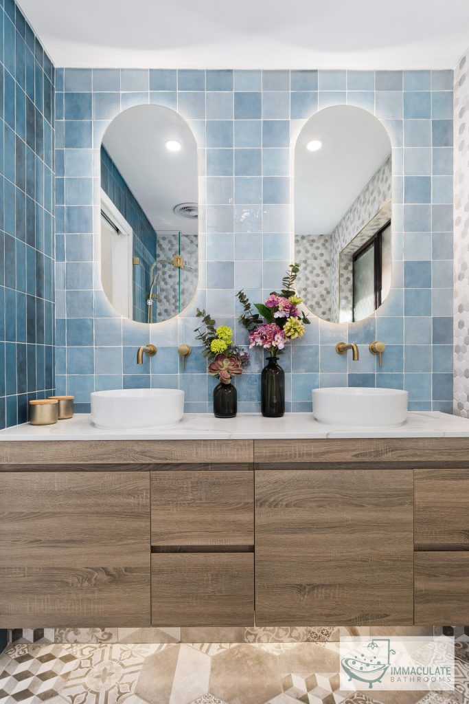 Modern Perth bathroom renovation with blue feature tiles, double basins, timber vanity, and brass tapware by Immaculate Bathrooms