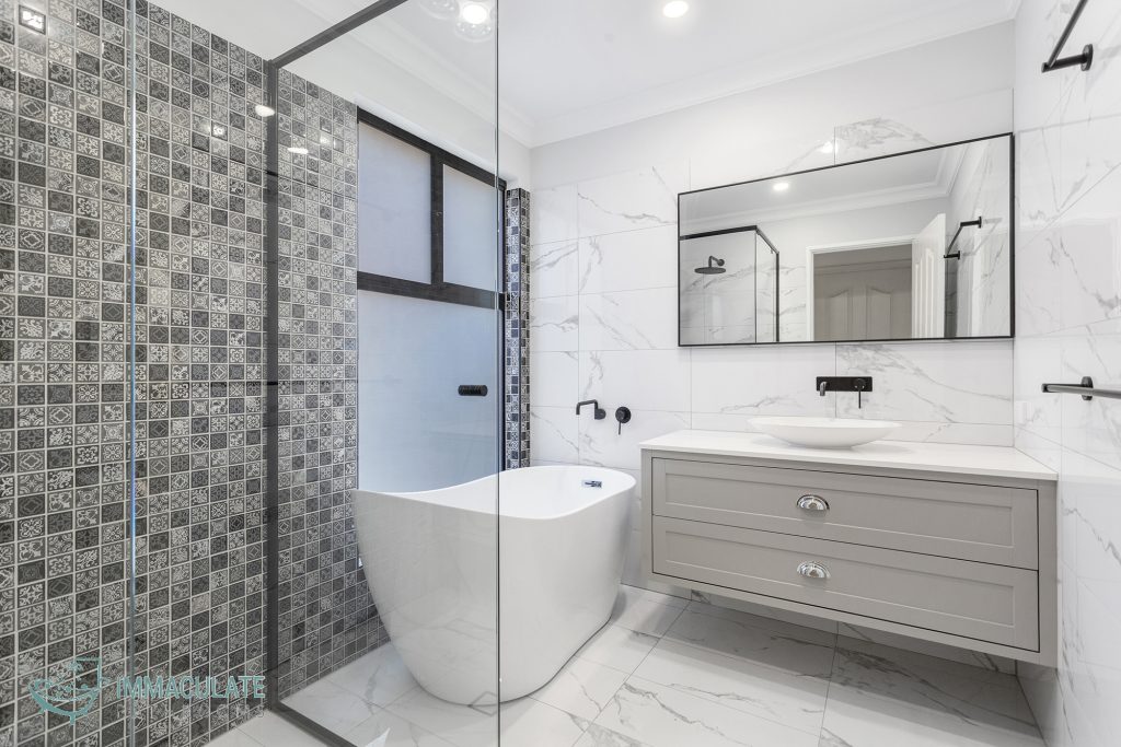 Modern Perth bathroom renovation with freestanding bathtub, patterned shower tiles, and marble-look walls by Immaculate Bathrooms