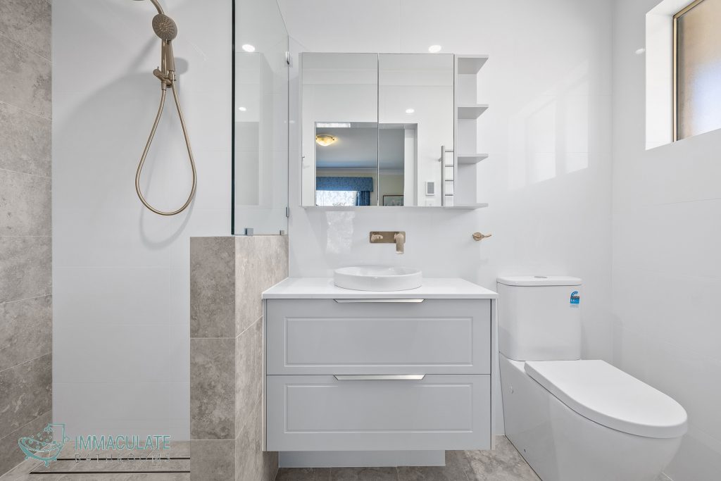Modern bathroom renovation with walk-in shower, grey vanity, mirrored cabinet, and brushed-gold tapware — Immaculate Bathrooms Perth.