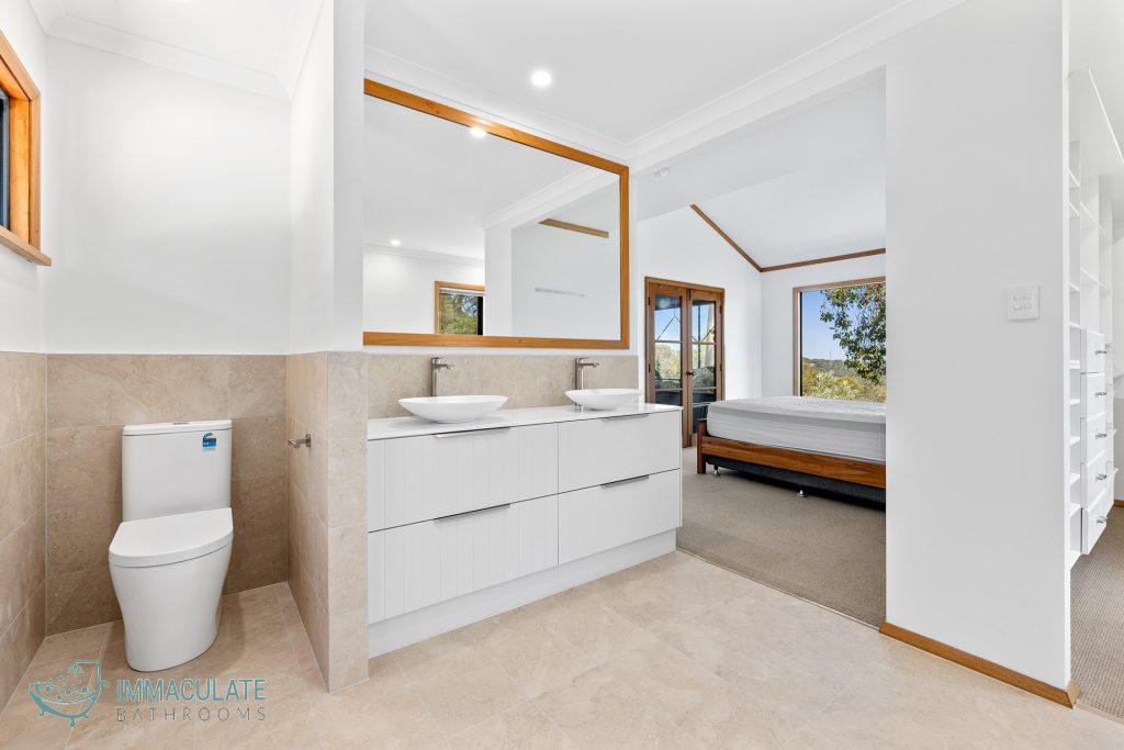 Open ensuite bathroom with double vanity, vessel basins, large mirror and beige floor tiles by Immaculate Bathrooms Perth