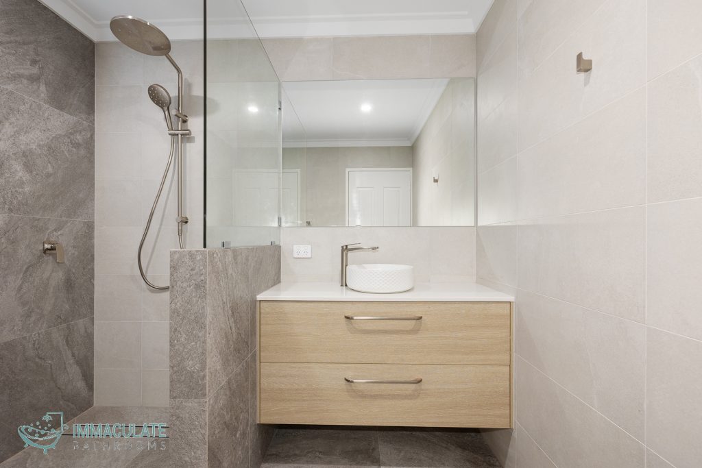 Modern bathroom with timber floating vanity, vessel basin, large mirror and grey walk-in shower by Immaculate Bathrooms Perth