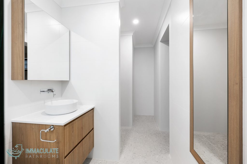 Modern Leederville ensuite with floating timber vanity, white wall tiles and stone flooring by Immaculate Bathrooms Perth