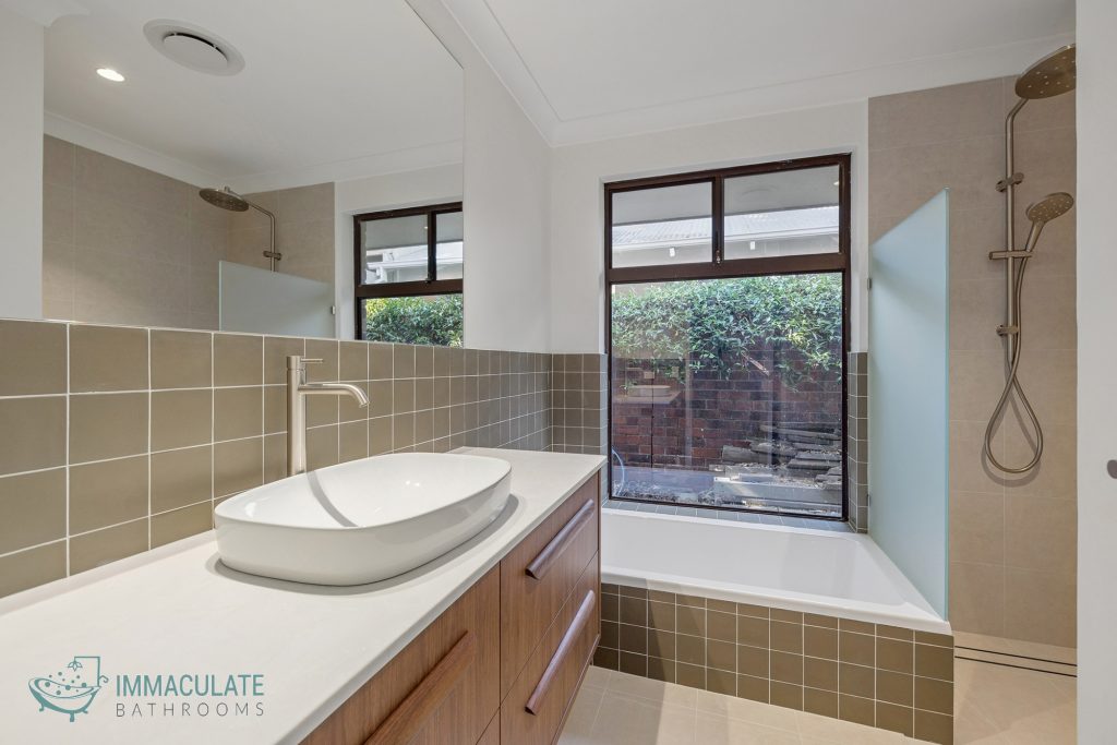 Modern bathroom renovation with timber vanity, vessel basin and shower bath in Perth